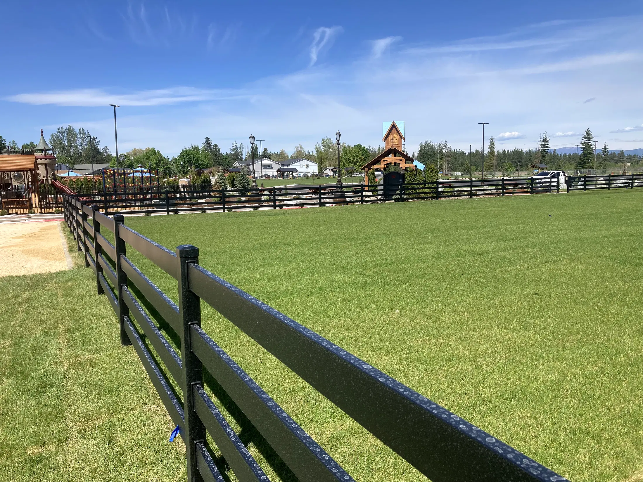 Fence leading toward playground and park at Faith Walk Community Fitness Park in Coeur d'Alene, Idaho