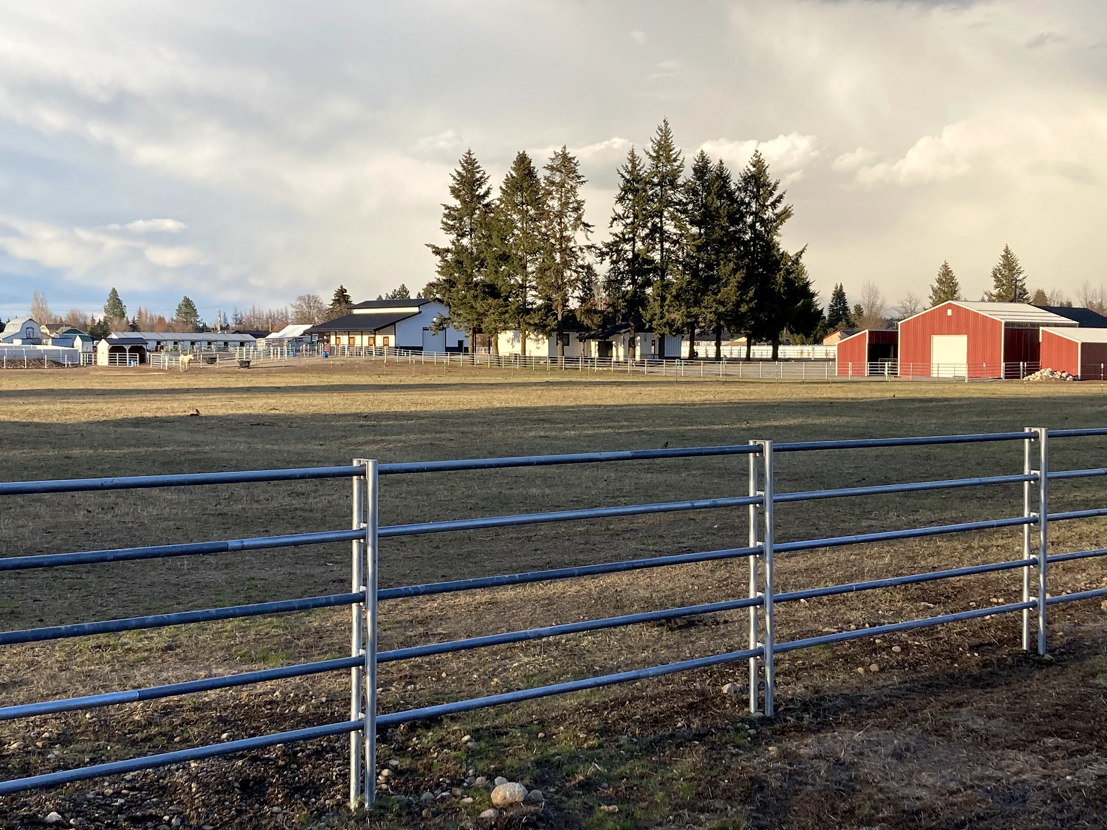 Noble Contour rail fence crossing the field toward the barn at the Lacey Avenue project