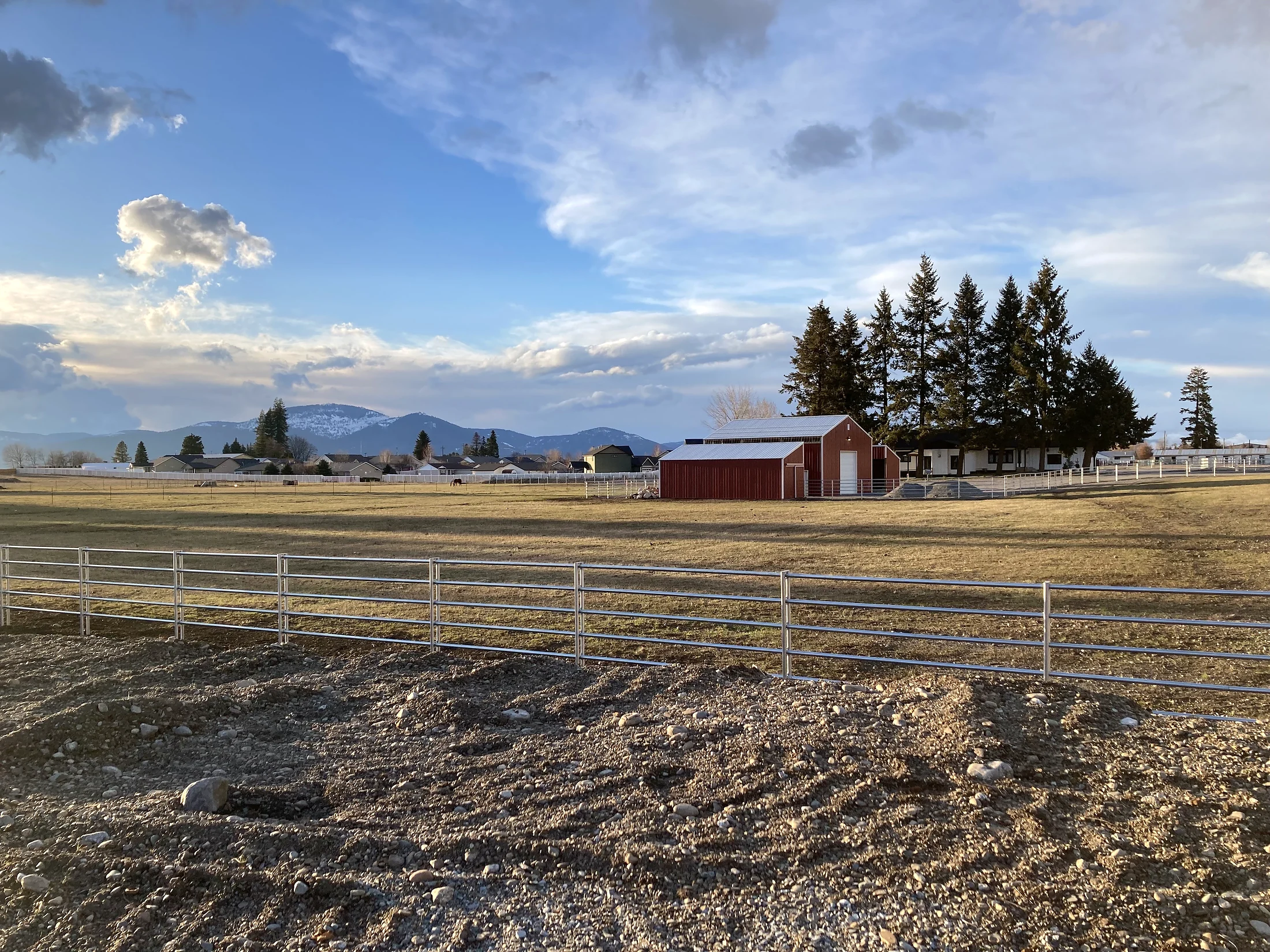 Noble Contour fence with barn and mountain backdrop at the Lacey Avenue project in Hayden, Idaho