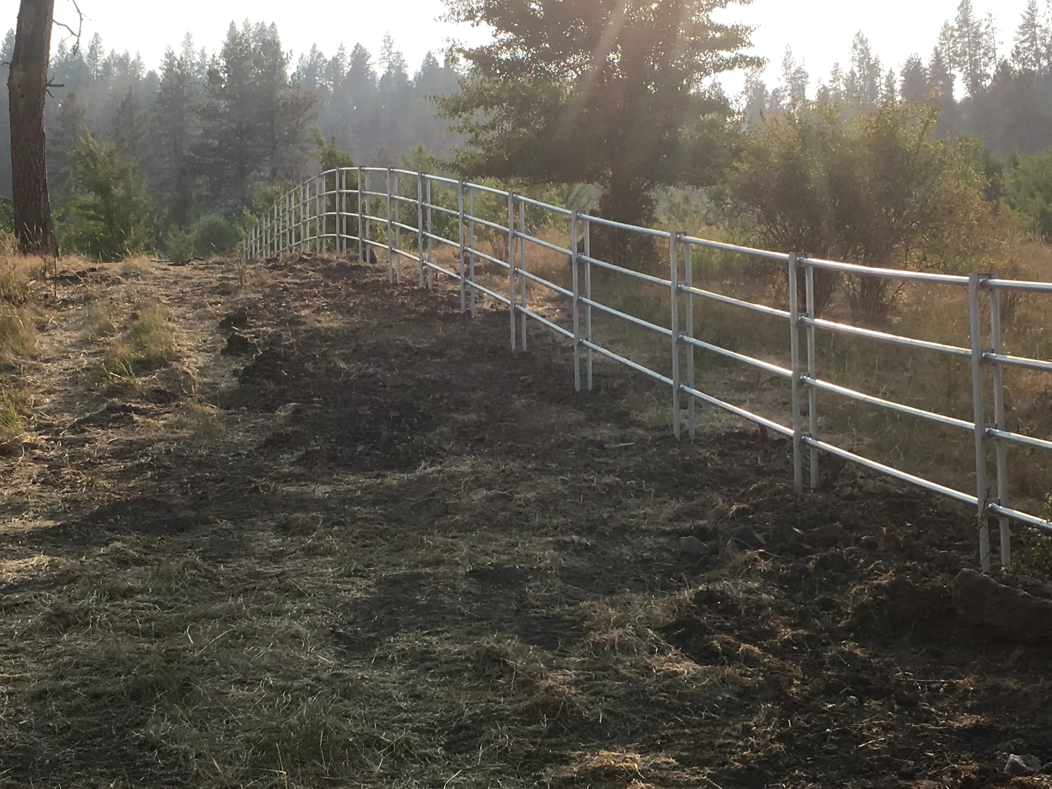 Backlit Noble Contour fence following a rough hillside near Stites, Idaho