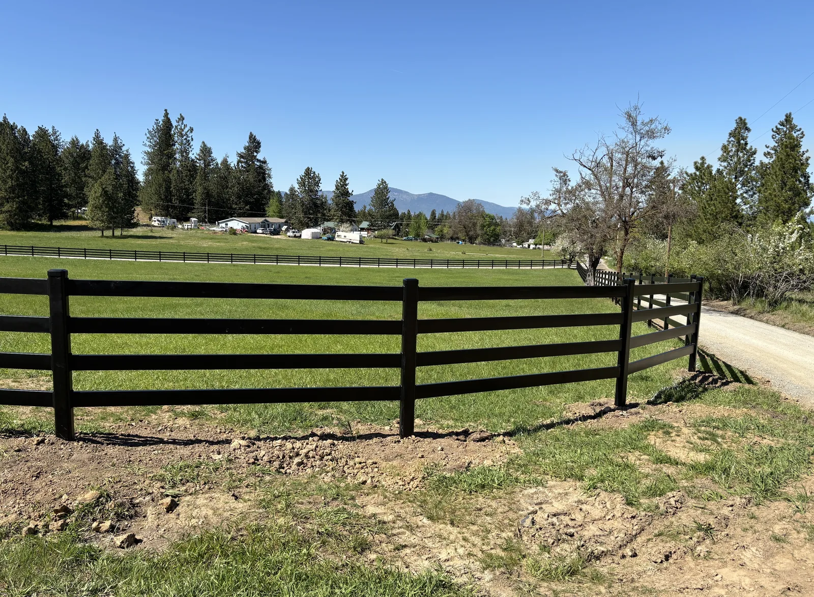 Four-rail black Buckley Steel Board corner section beside the pasture at North Idaho Dream Ranch.
