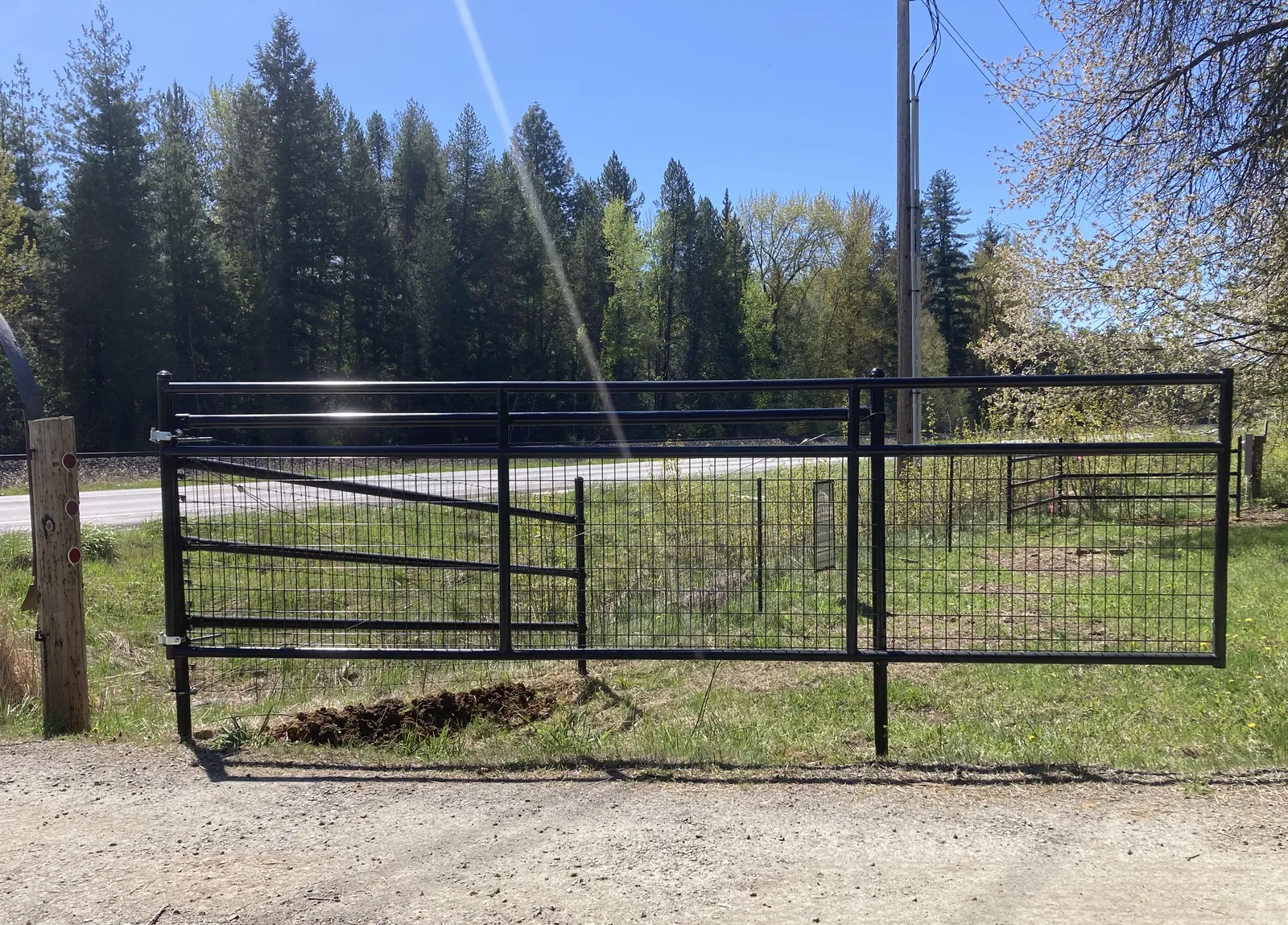 Black mesh gate and steel posts at the North Idaho Frontier fence project.