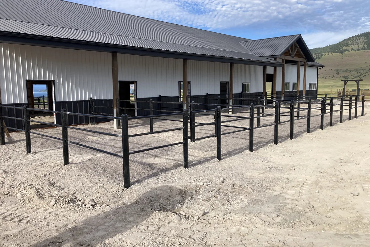 Black rail fencing around a horse-property paddock