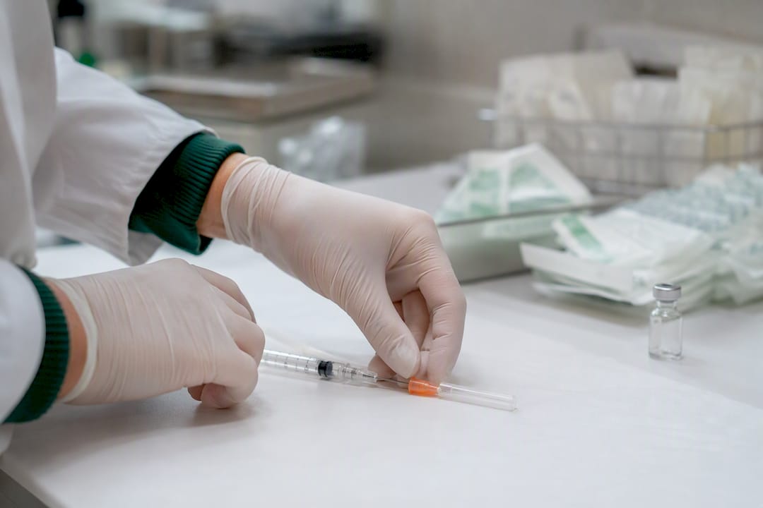 Hands preparing sterile injection in lab