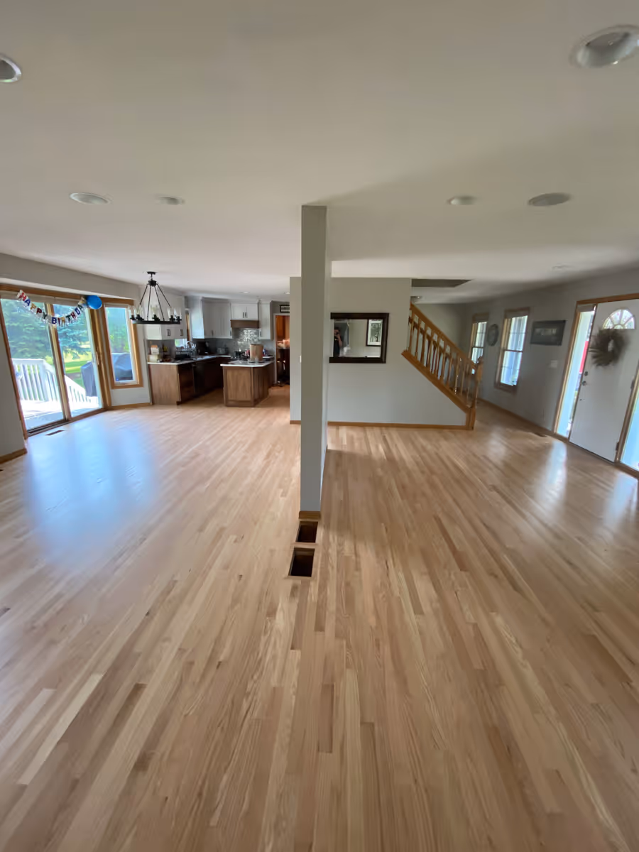Wide ange photo of a living and dinig area of an open floor plan home with nice hardwood floors