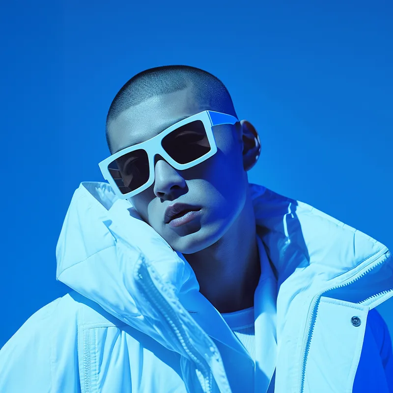 Man wearing white jacket and sunglasses against bright blue background.