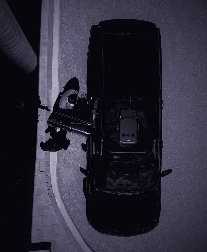 An OZINT operator at a client vehicle, seen from above