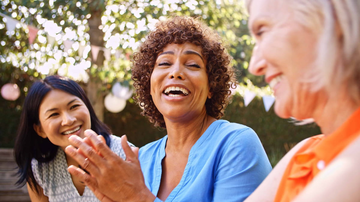 Smiling people celebrating together outdoors at a family gathering.