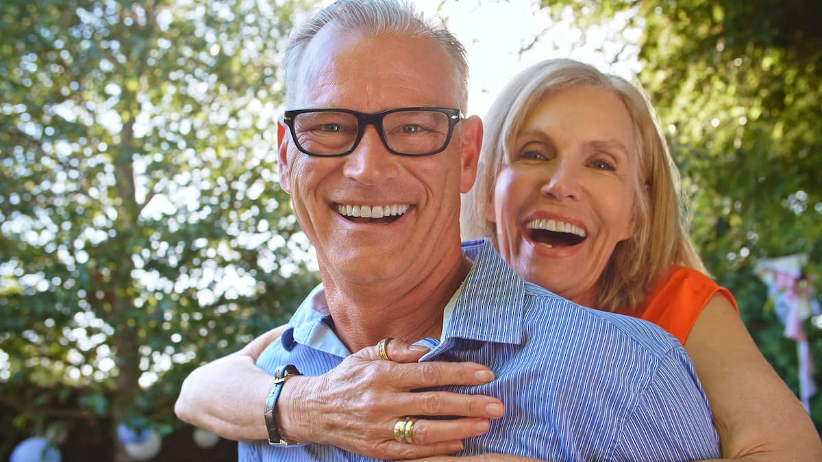 An older couple smiling together outdoors