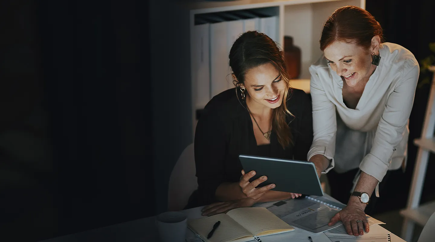 Two women looking at something on a tablet.