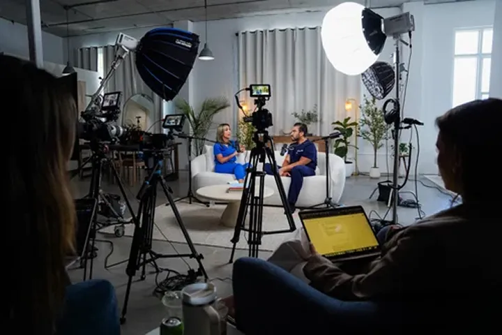 A group of people in a room with cameras.