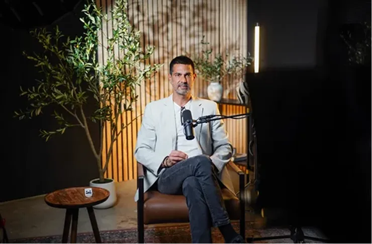 A man sitting in a chair in front of a microphone.