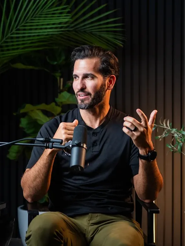 A man sitting in a chair holding a microphone.