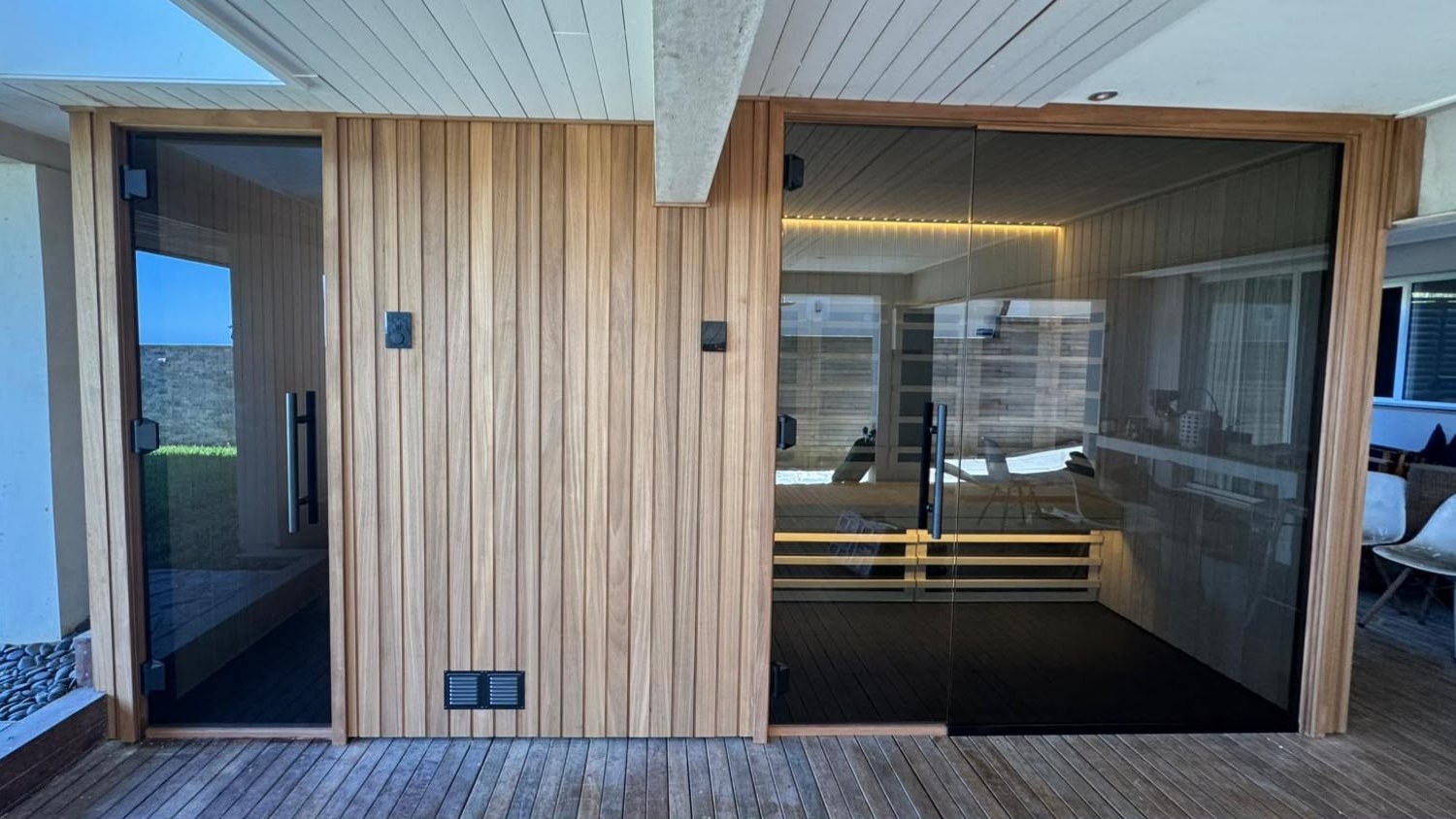 A traditional and an infrared sauna side by side in Coledale, lined in natural Aspen and clad in warm Ayous shadowgap, with a sunroof and a window to the surf.