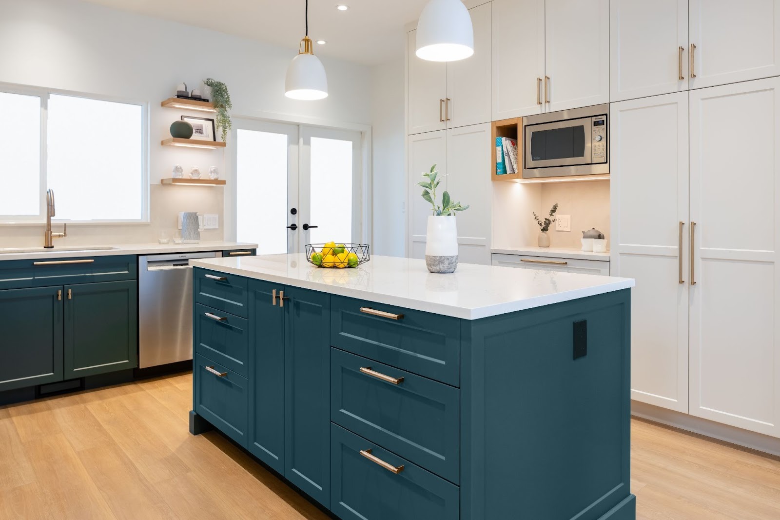 Bright modern kitchen with homeowners and a designer discussing renovation details at the island