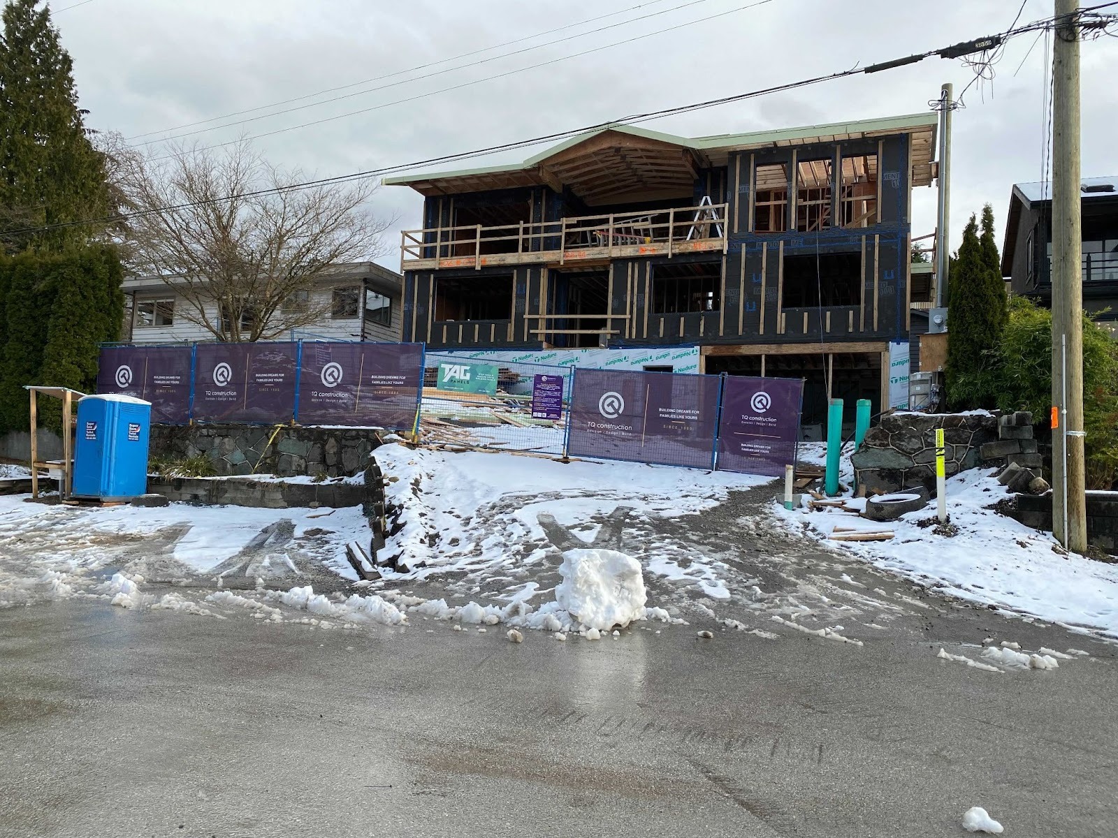 Residential custom home construction site with framing and crew