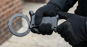 TCH total control handcuffs held by security officer.