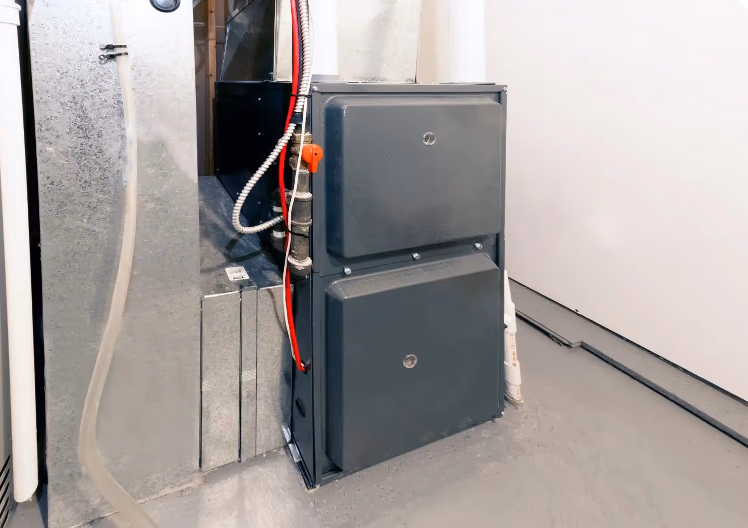 A newly installed, modern high-efficiency forced-air furnace sits in a utility closet or basement.