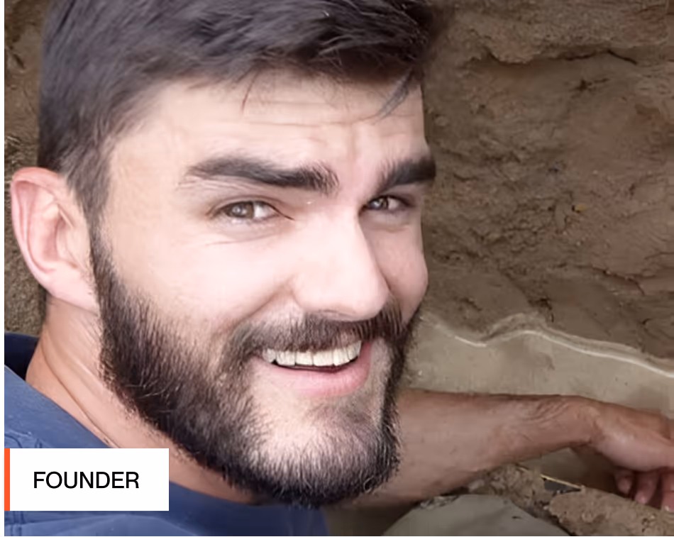 Rich Jordan, founder of Strongpoint Talent. Smiling bearded man with dark hair leaning against a rough textured wall.