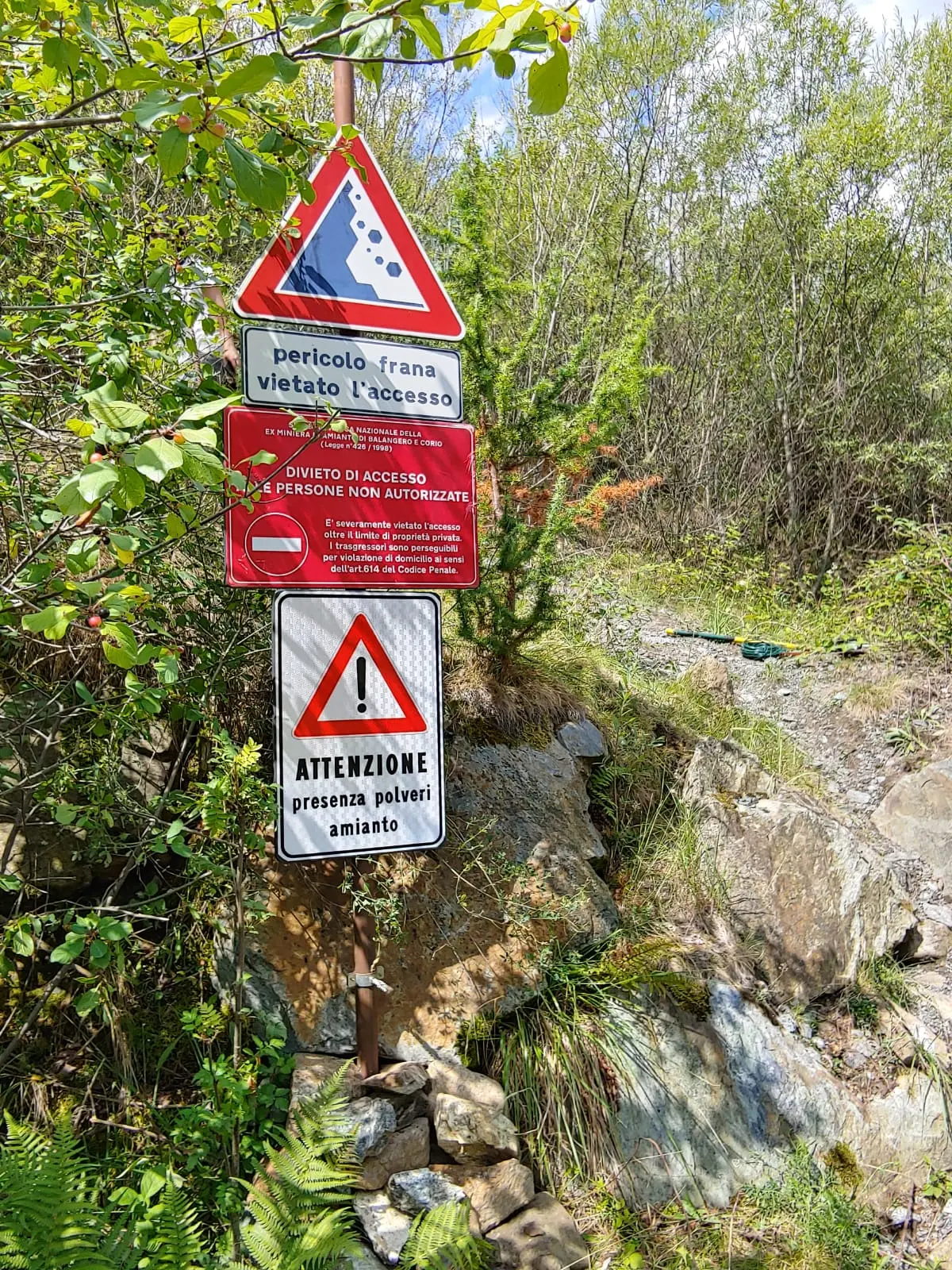 Cartelli di pericolo frana, divieto di accesso e presenza polveri di amianto lungo il perimetro della miniera