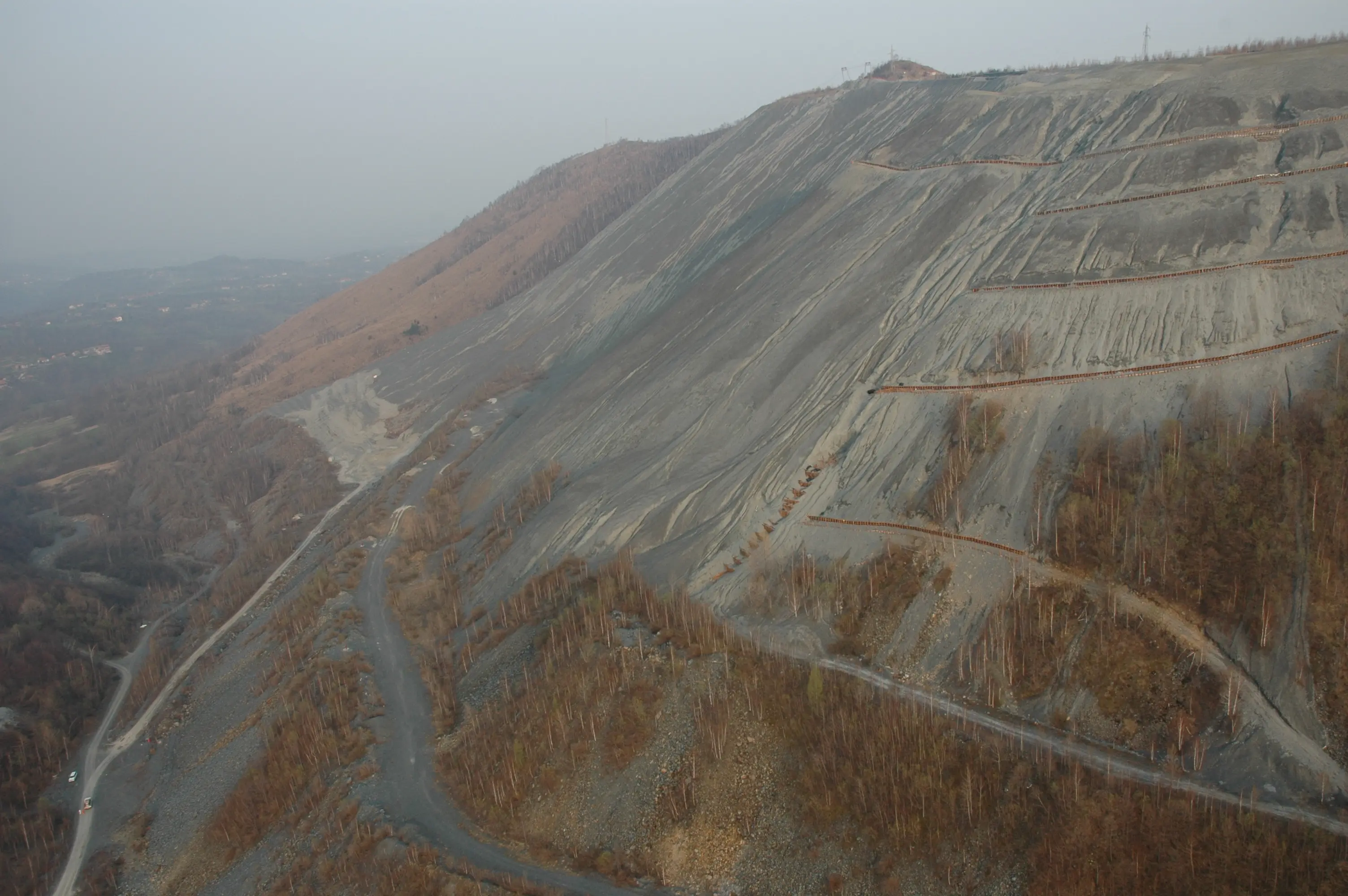 Grande discarica mineraria dell’ex miniera di Balangero con versanti rimodellati e opere di stabilizzazione