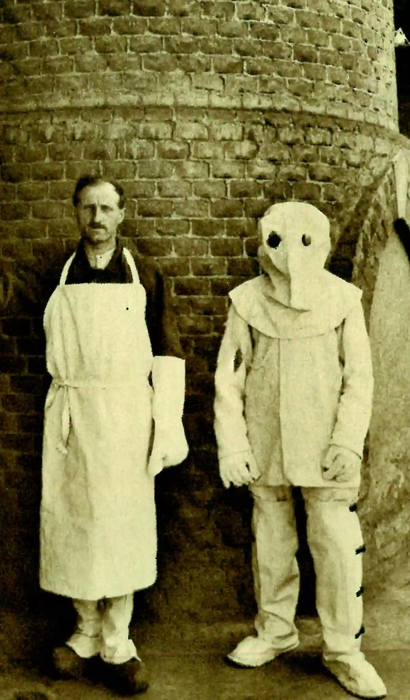 Fotografia storica di lavoratori con indumenti protettivi in fibra di amianto utilizzati nell’industria