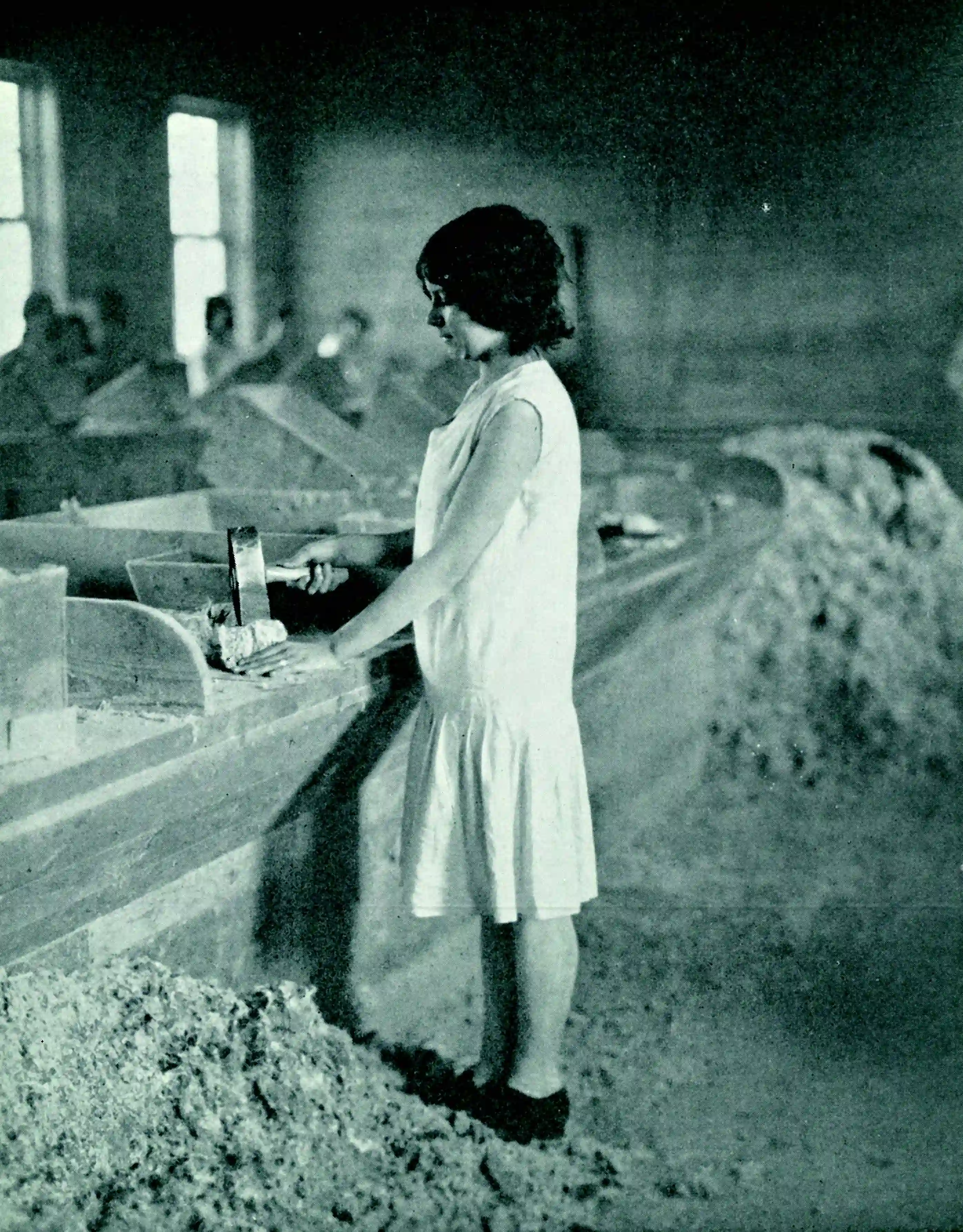 Fotografia storica di una lavoratrice durante la lavorazione di fibre di amianto in ambiente industriale