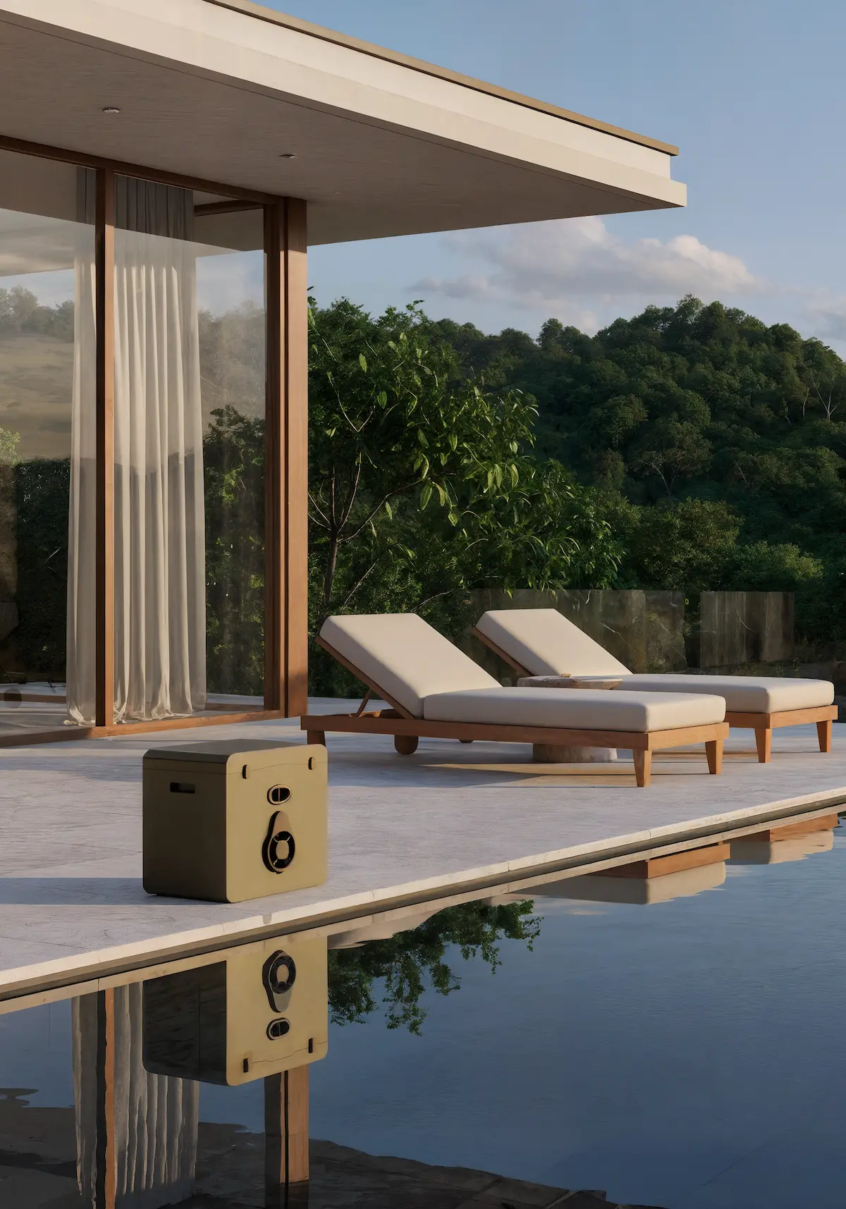 Borne GRéco installée discrètement sur une terrasse en bois au bord d'une piscine, avec une villa moderne en arrière-plan.