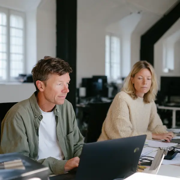 Membres de l'équipe GRéco travaillant sur ordinateur dans un bureau moderne, symbolisant le savoir-faire humain derrière notre technologie anti-moustique.