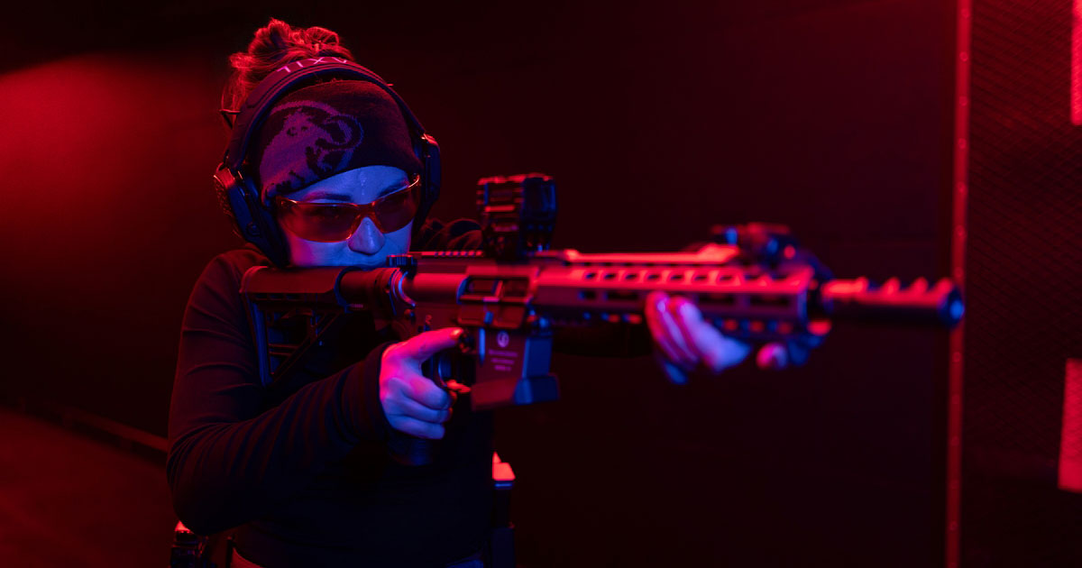 Logo with the text 'True Aim Academy' where the letter 'i' in 'Aim' is replaced by a bullet hole and a bullet underline below 'Academy'.