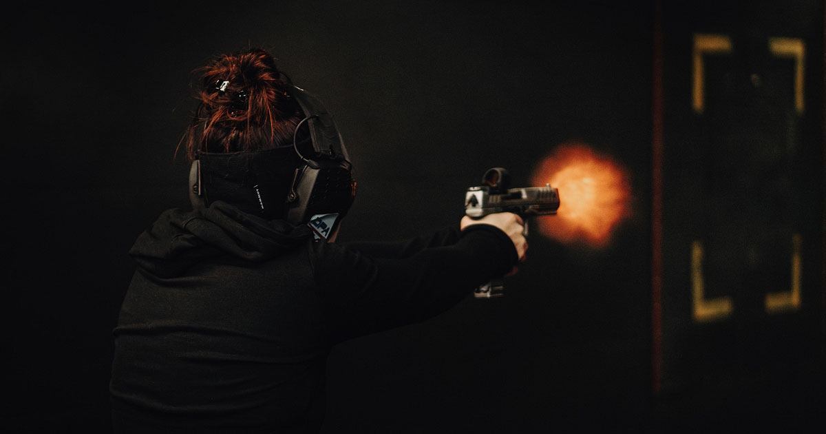 Two pistols, one Steyr Arms 9x19 and one Walther, resting on a shooting target next to black ear protection and scattered brass .