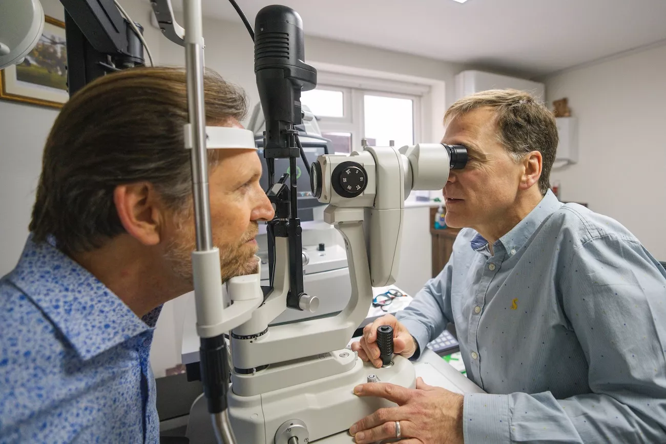 Optometrist performing a slit lamp eye examination on a patient