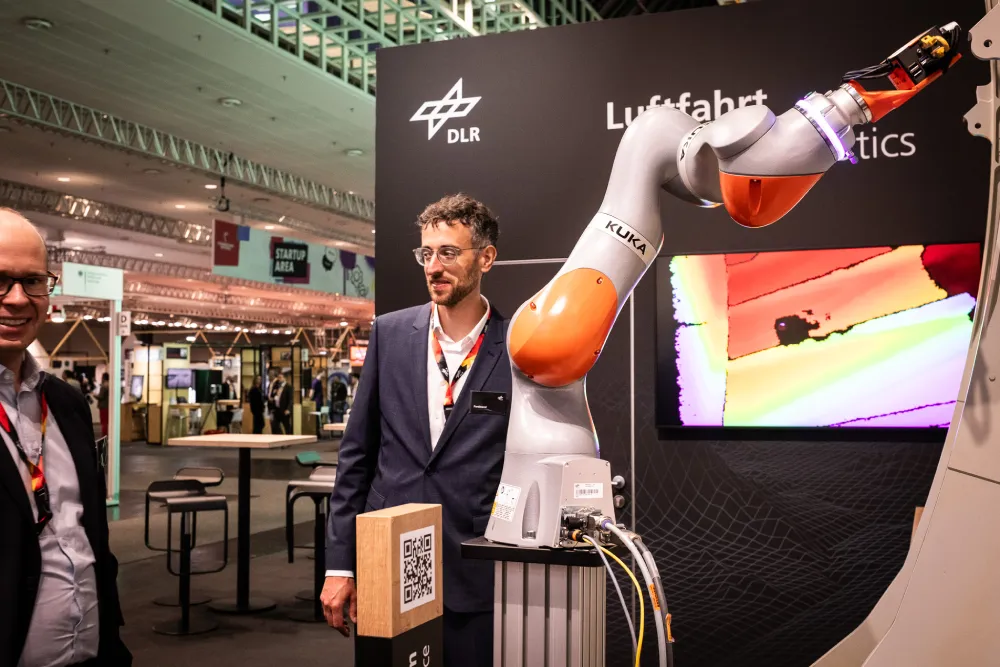 Aussteller mit Industrieroboter an einem Stand der HANNOVER MESSE 2026