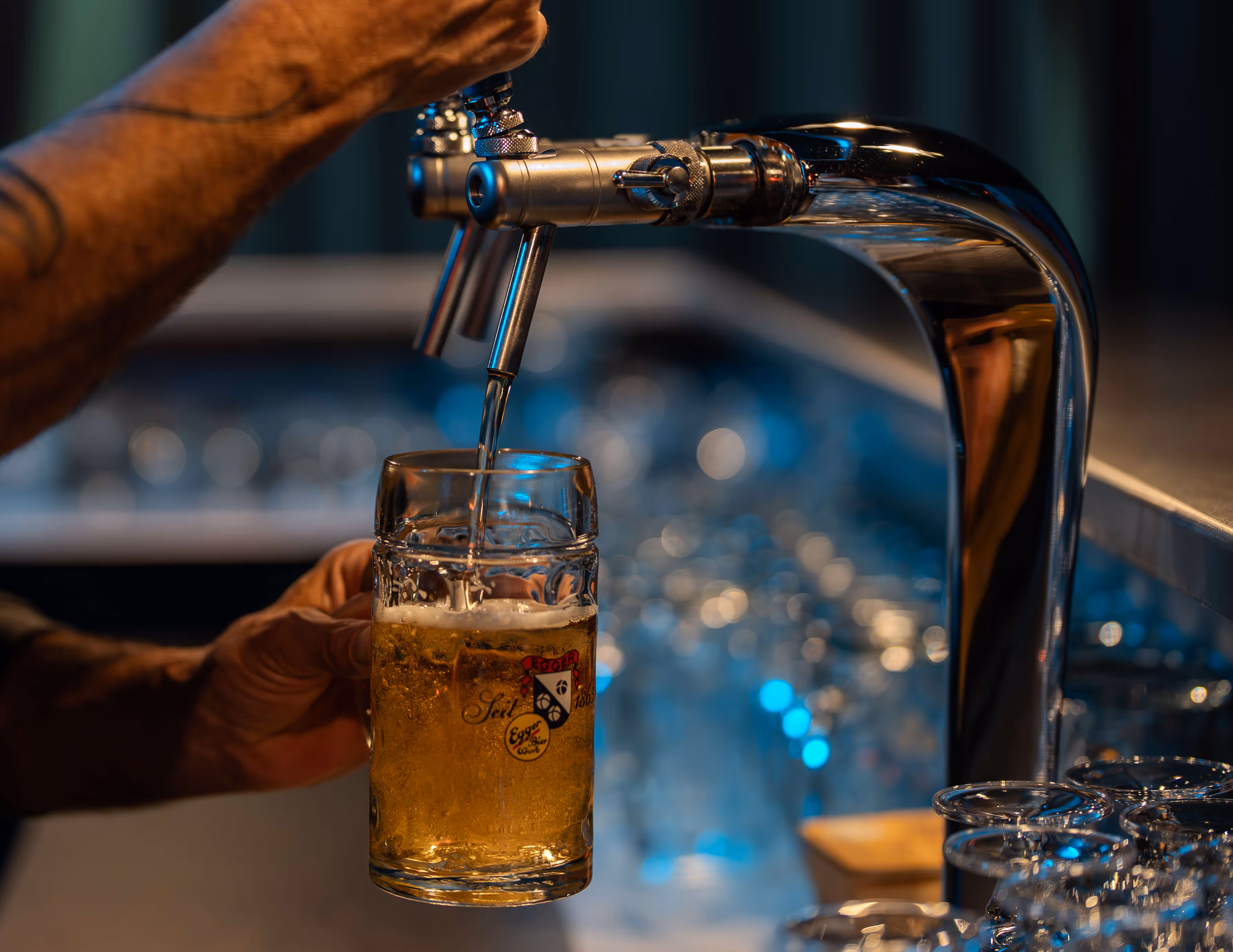 Bruno schenkt ein Bierglas an einer Zapfanlage in der Barbar ein.
