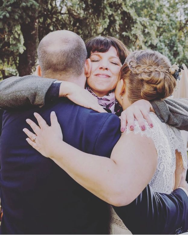 Drei Personen umarmen sich herzlich im Freien, Anna Fasciani - freie Traurednerin -  mit glücklichem Gesichtsausdruck in der Mitte.