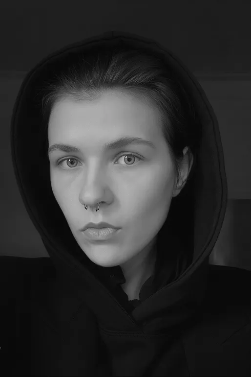 Black and white close-up portrait of a person wearing a black hoodie with a septum piercing.