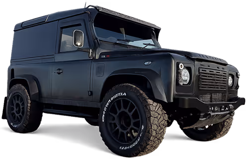 Black off-road Land Rover Defender vehicle with large tires and 'Devon Defenders' logo.