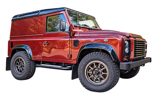 Black off-road Land Rover Defender vehicle with large tires and 'Devon Defenders' logo.