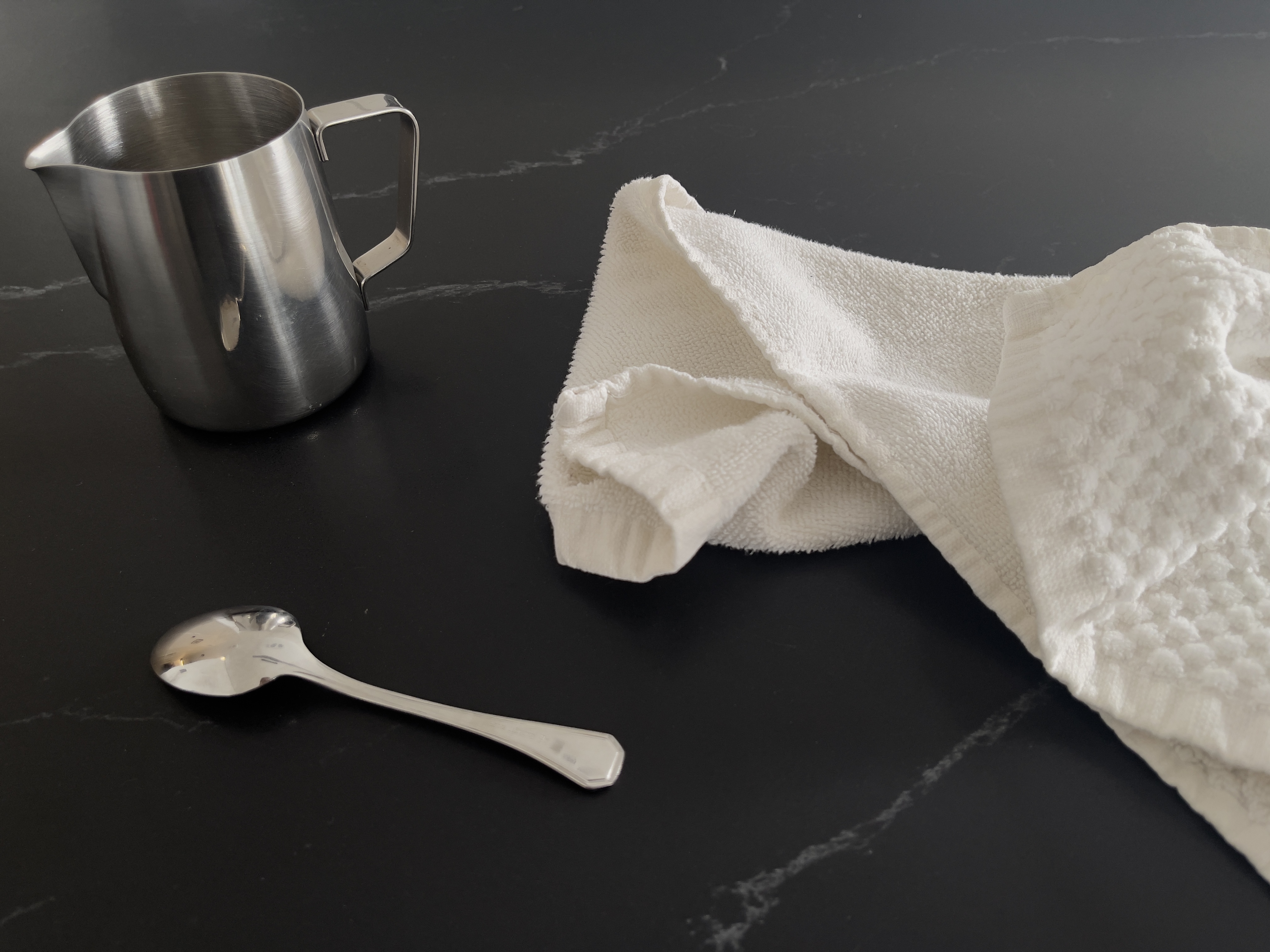 Detal pokazujący teksturę czarnego blatu ze spieku, z kontrastowymi elementami dekoracyjnymi.