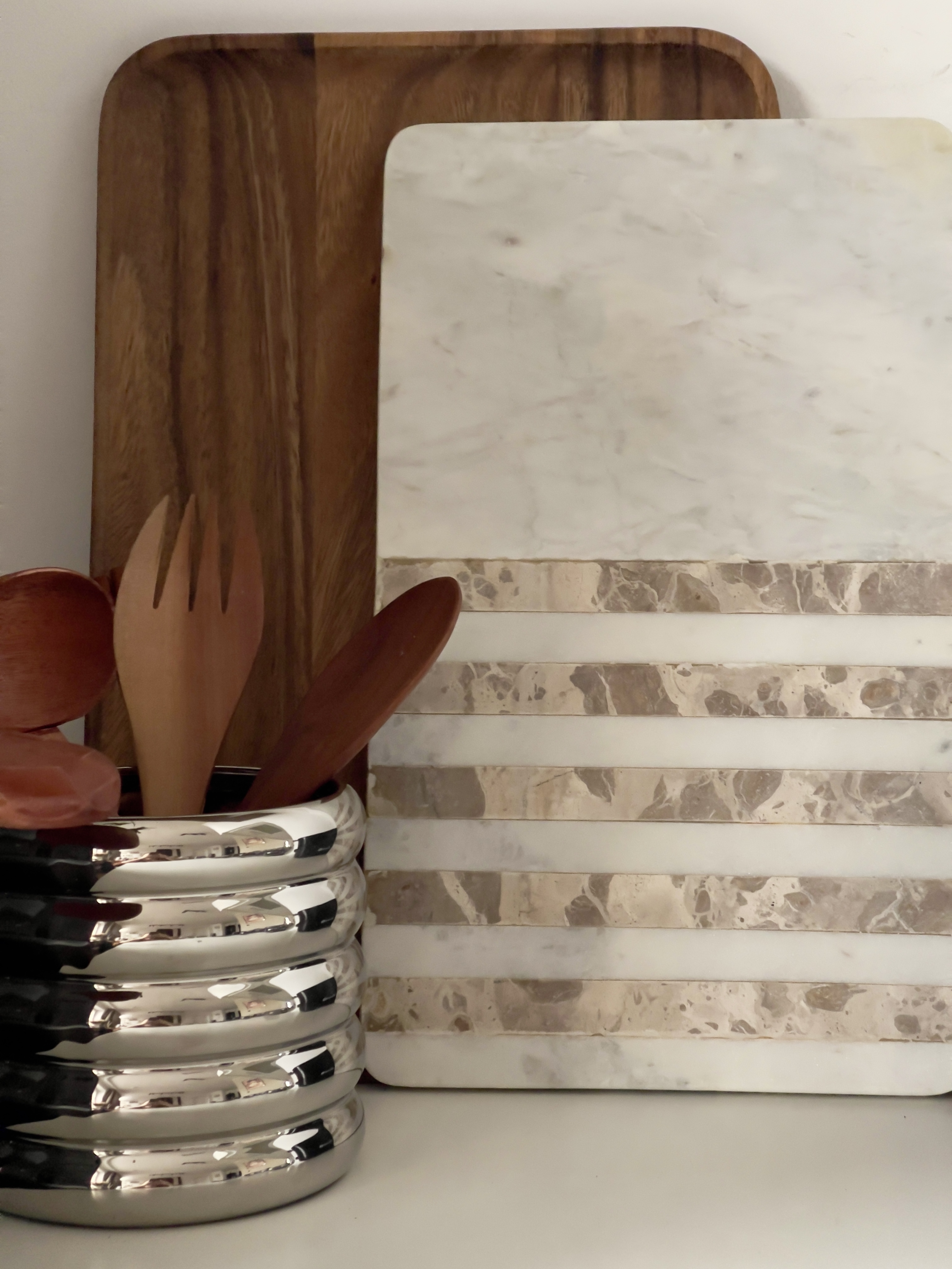 Detal pokazujący dekoracyjne deski do krojenia z marmuru i drewna egzotycznego.