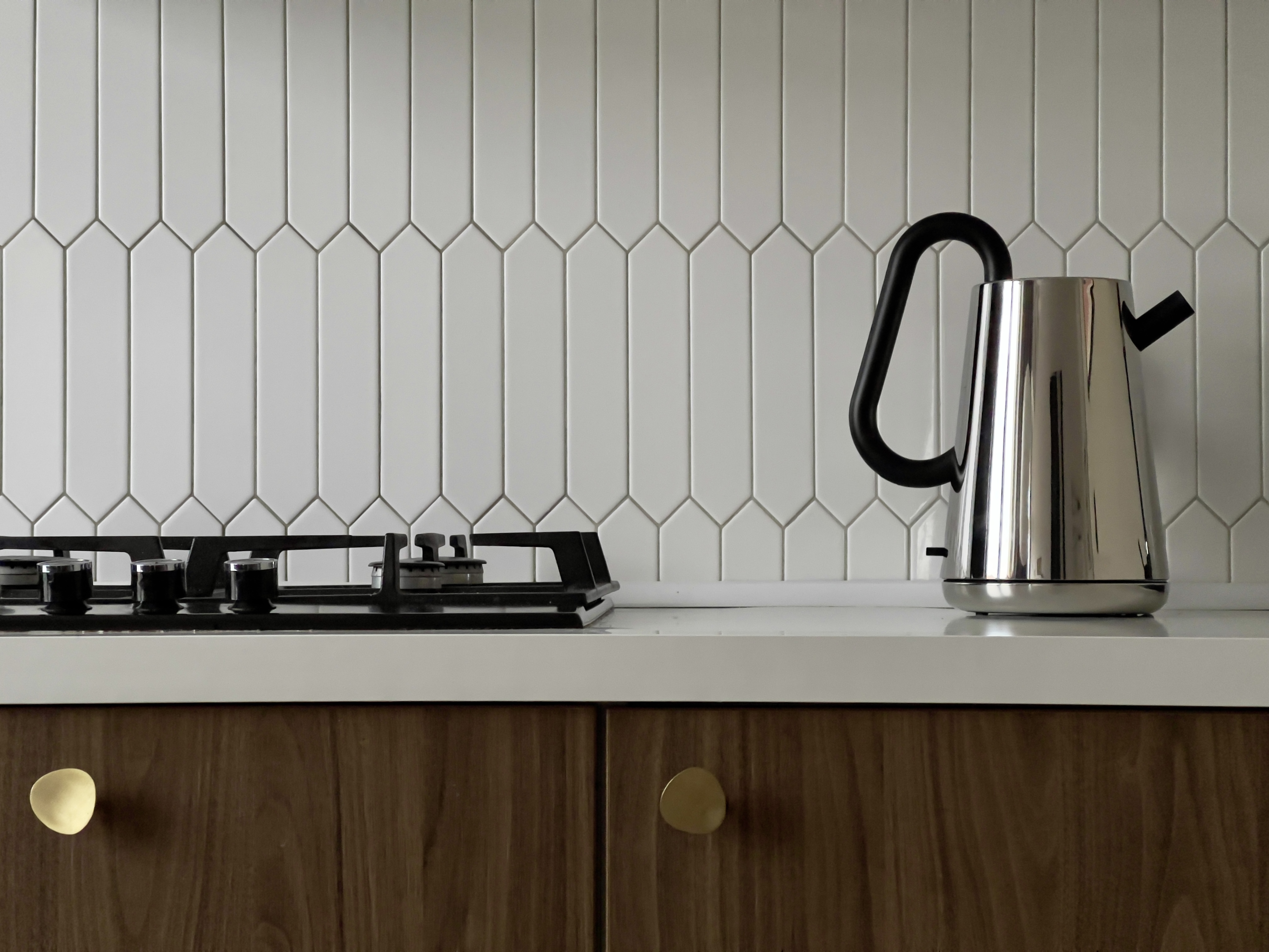 Detal realizacji pokazujący wzór i teksturę kafli nad blatem kuchennym.