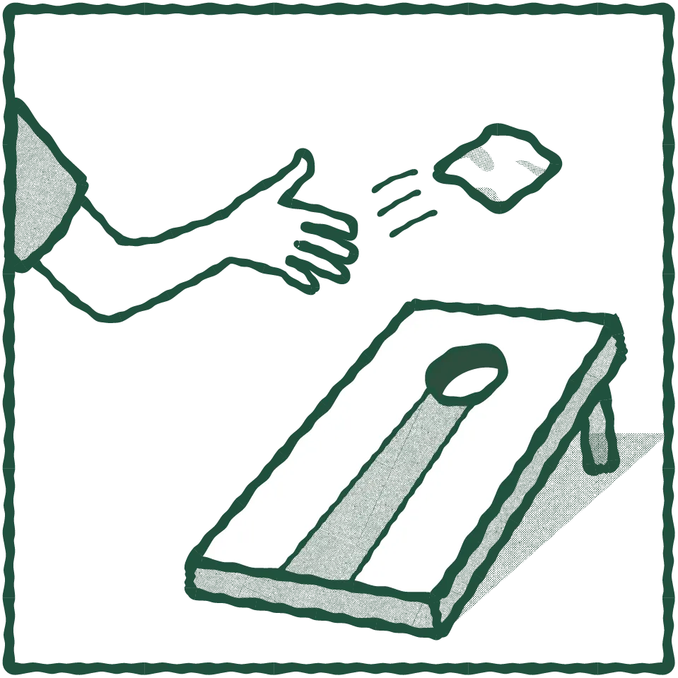 Hand tossing a bean bag toward a cornhole board with a hole at the far end.