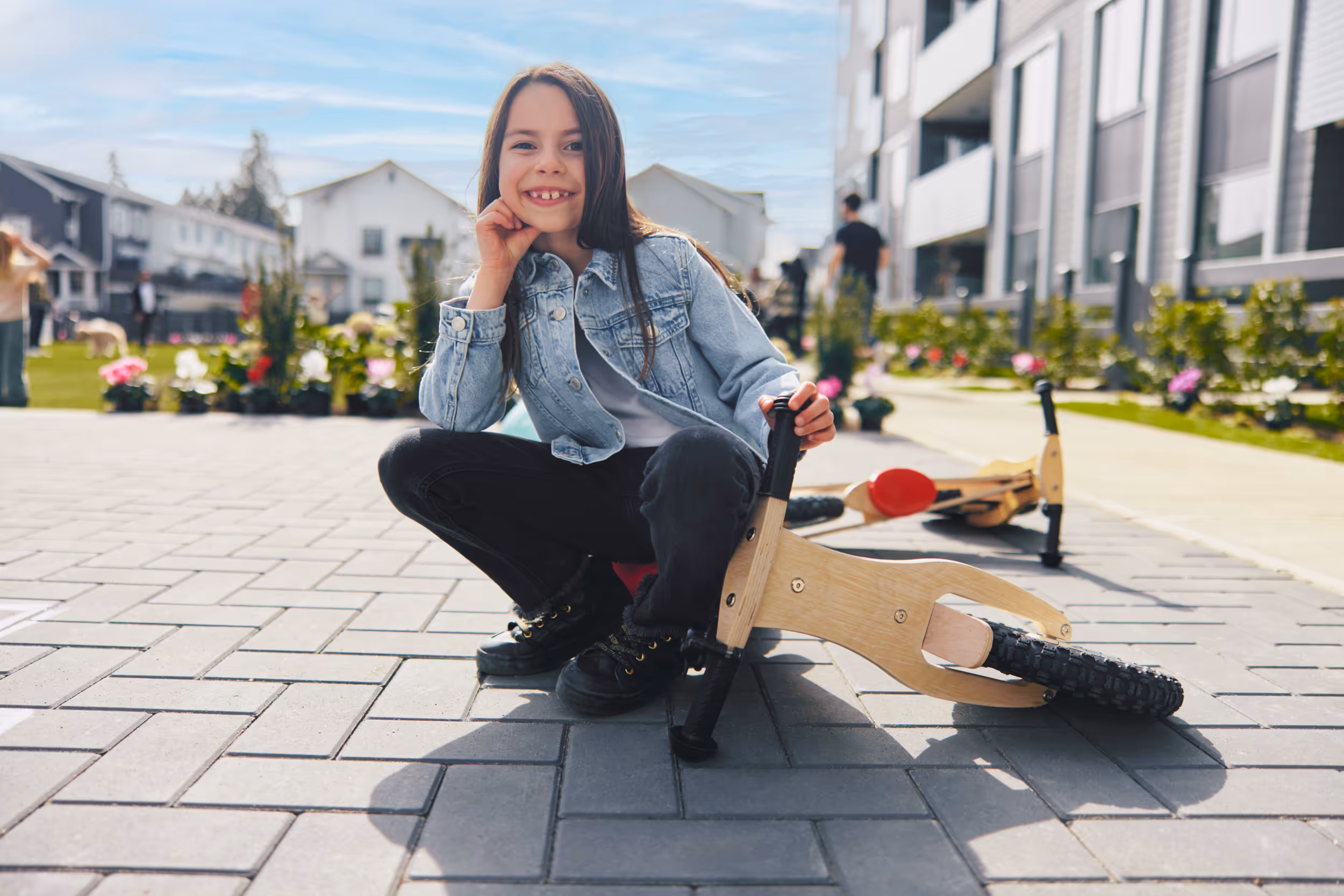 Child playing on scooter at Fleetwood Village playground courtyard