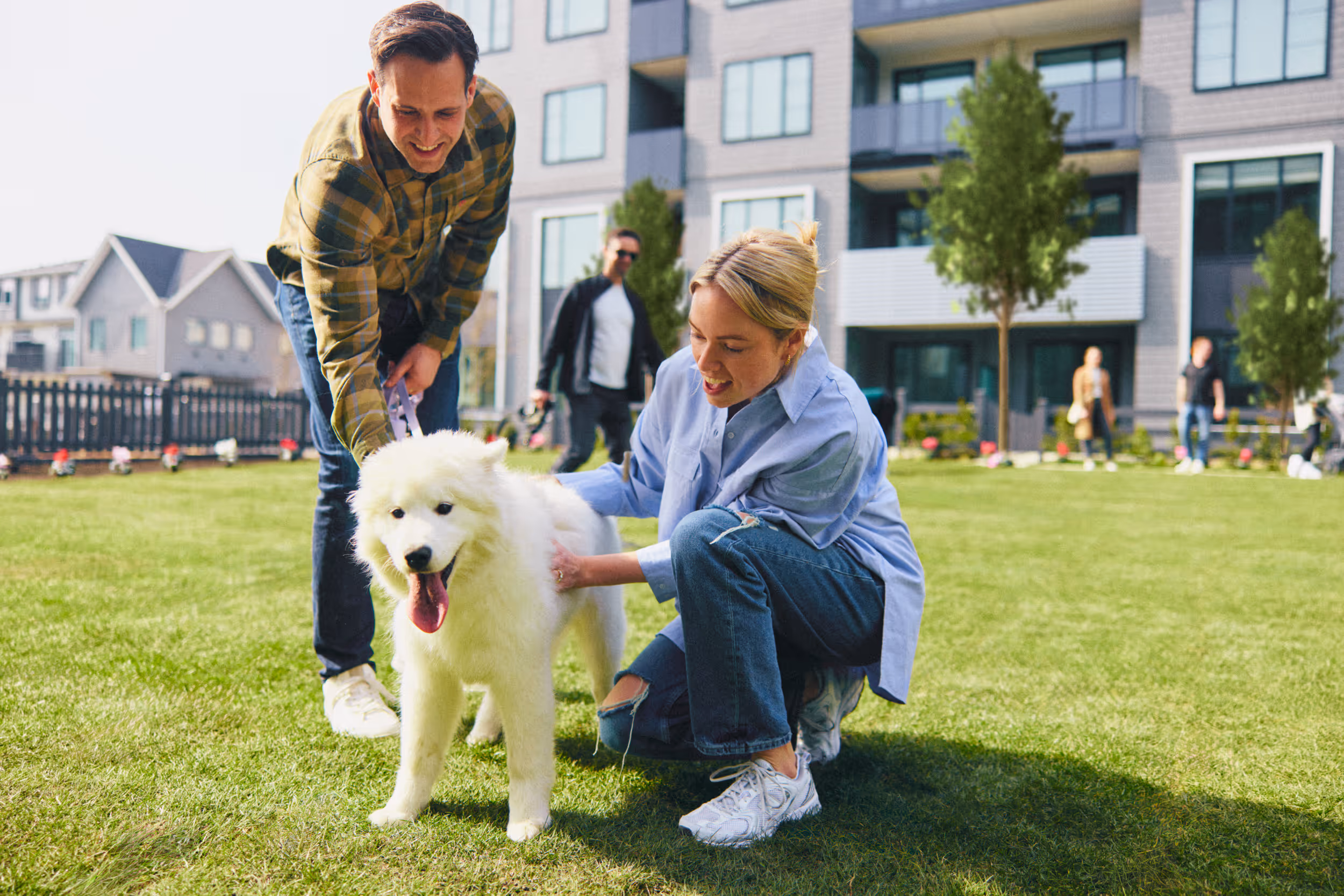 Couple with dog walking through landscaped courtyard and park near in Surrey BC