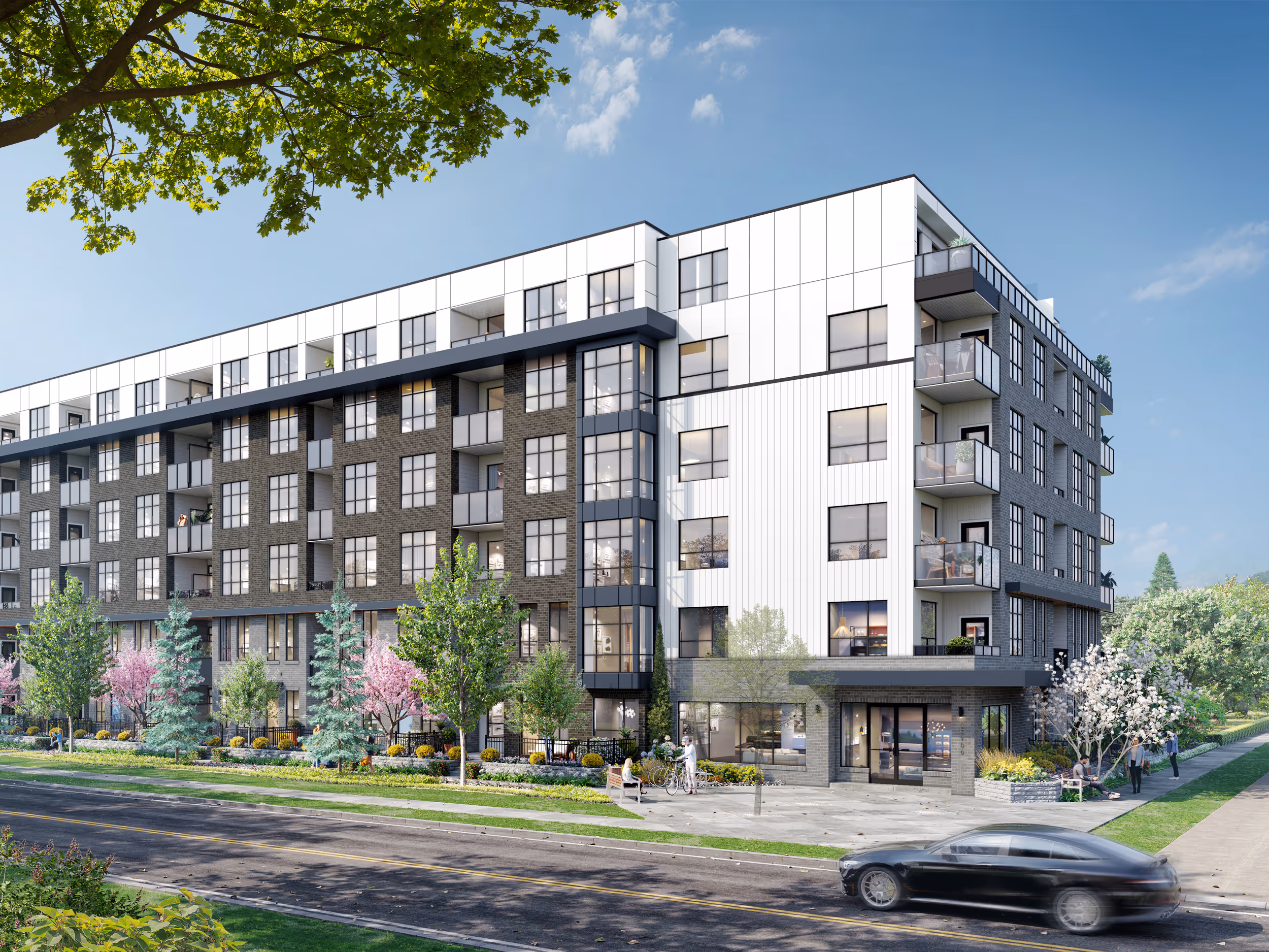 Modern multi-story apartment building with balconies, surrounded by trees and landscaped greenery, with a blurred black car passing on the street.