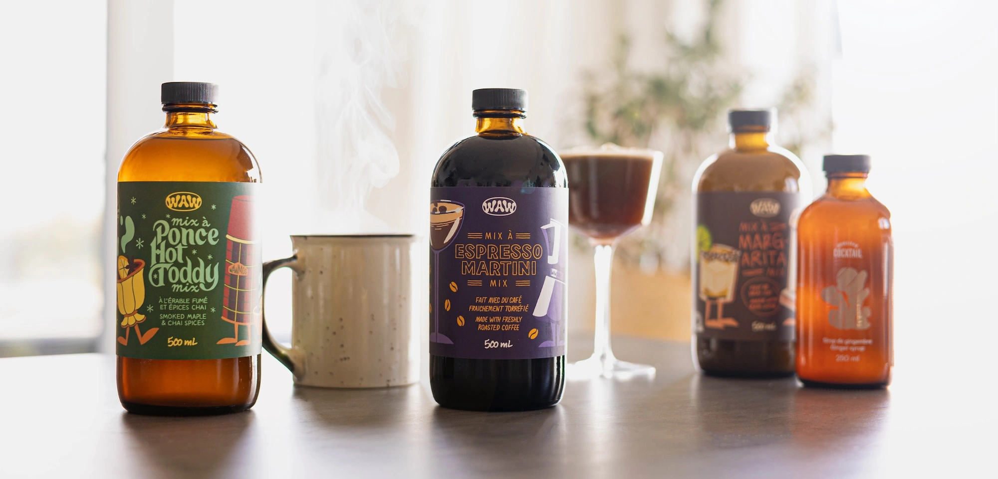 Several bottles of WAW and Monsieur Cocktail products on a table.