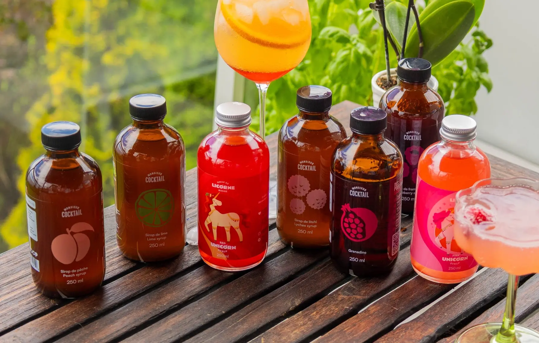 Several bottles of WAW and Monsieur Cocktail products on a table.