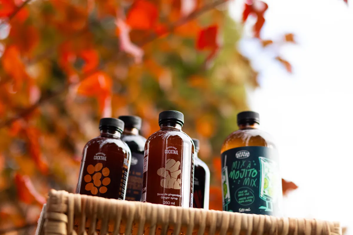 Several bottles of WAW and Monsieur Cocktail products on a table.
