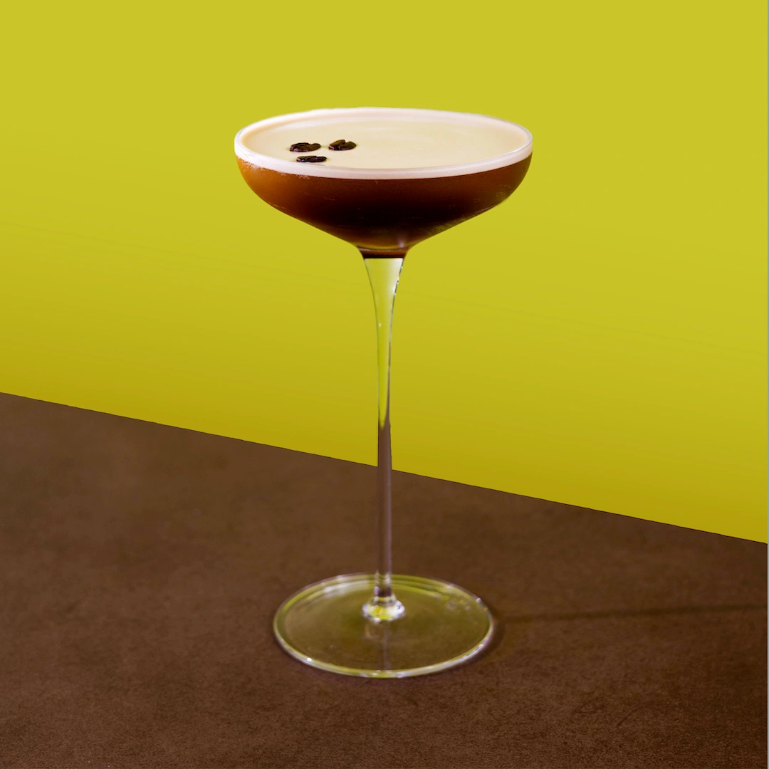 Cocktail made with vodka and espresso martini mix on a green background.
