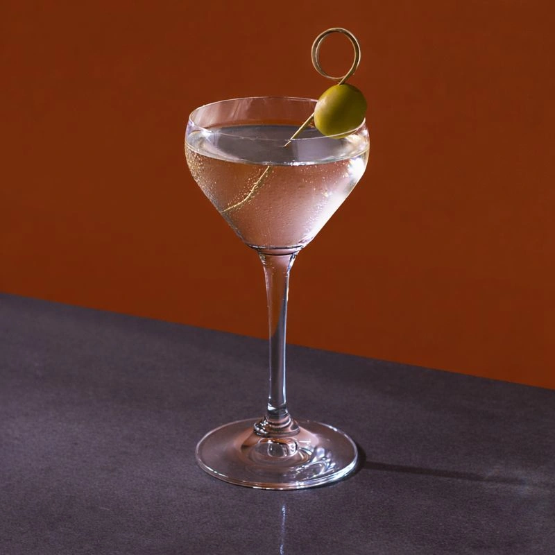 Cocktail made with gin and dry vermouth on a brown background.